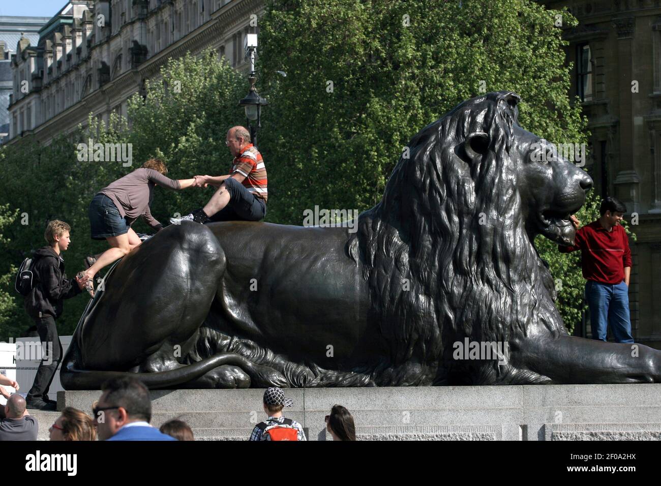 25 avril 2011. Londres, Angleterre. Les touristes se bousculent à bord des lions et posent pour prendre des photos à Trafalgar Square. Crédit photo: Charlie Varley/Sipa USA Banque D'Images