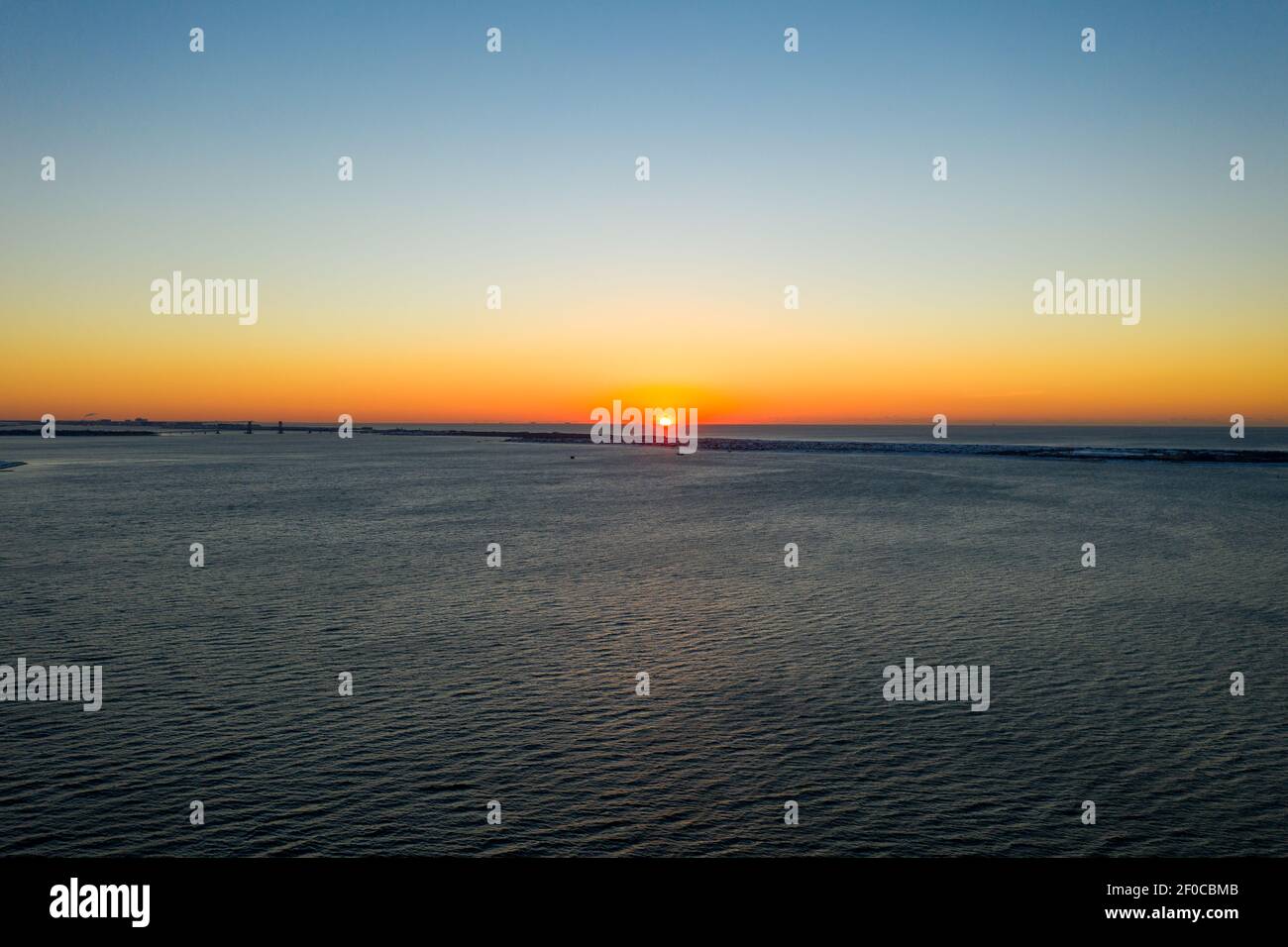 Vue aérienne d'une plage enneigée de Coney Island Beach pendant l'hiver au lever du soleil à Brooklyn, New York. Banque D'Images