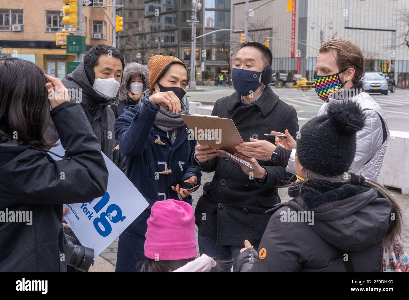 NEW YORK, NY - MARS 6: Les piétons signent un formulaire aux volontaires pour Andrew Yang dans le Columbus Circle de Manhattan le 6 mars 2021 à New York. Le candidat mayonnaise de la ville de New York, M. Andrew Yang, et les bénévoles recueillent des signatures dans le cercle Columbus de Manhattan pour être sur le scrutin primaire démocratique comme M. Yang campagne pour le maire. Banque D'Images