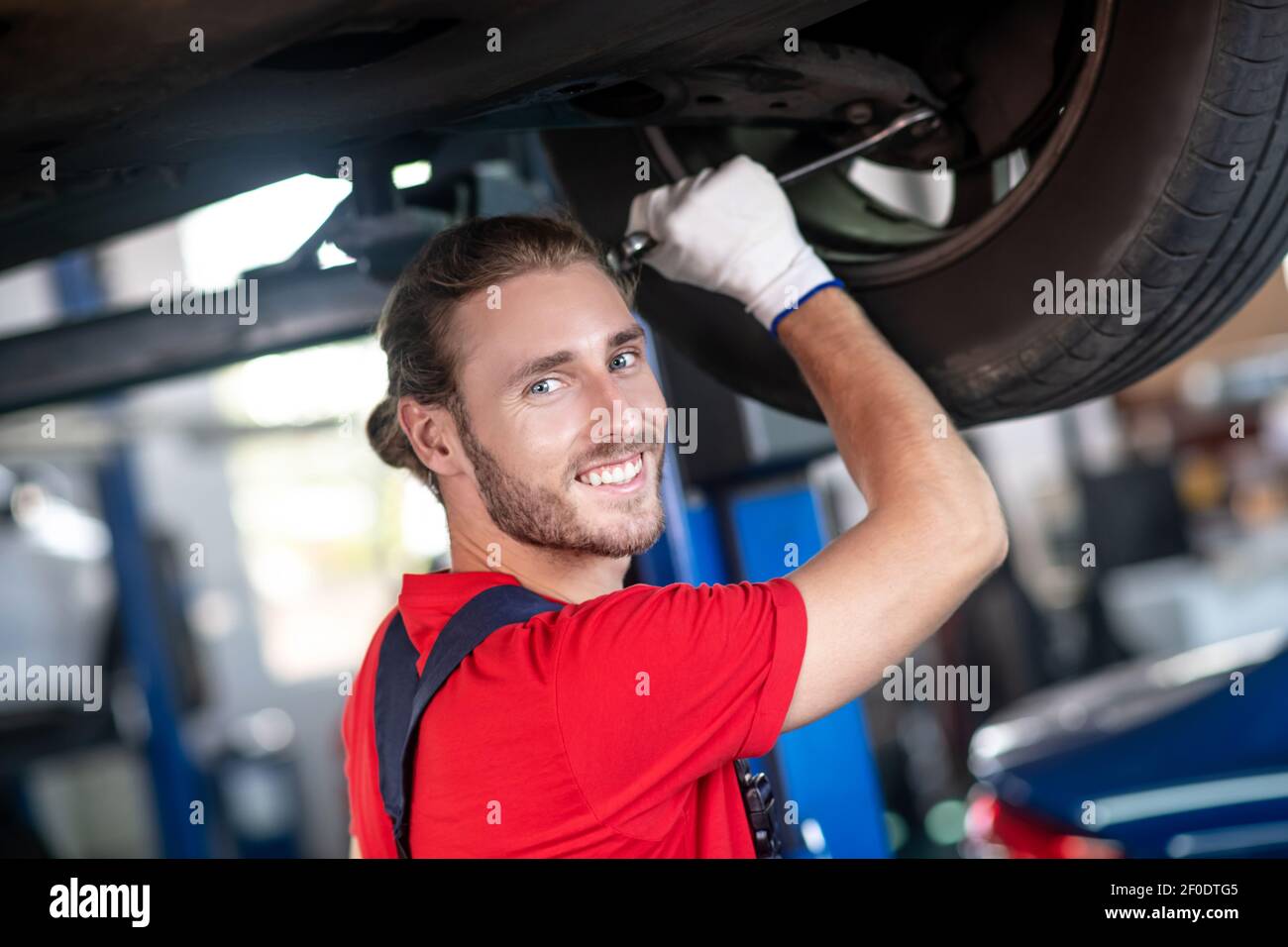 Homme tenant les mains près de la roue de la voiture Banque D'Images