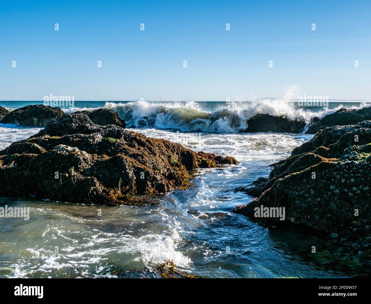 Vagues et rochers dans la zone intertidale à Tar Pits Beach à Carpinteria Californie par une journée ensoleillée. Banque D'Images