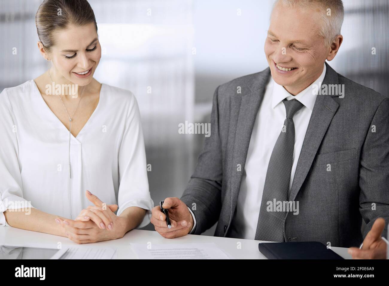 Homme d'affaires et femme âgés assis et communiquant au bureau. Des ...