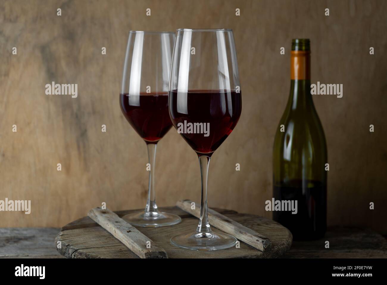 Deux verres de vin rouge. La bouteille de vin est sur la table. Vin de fond. Encore la vie. Boisson alcoolisée dans un verre. Arrière-plan en bois. Banque D'Images