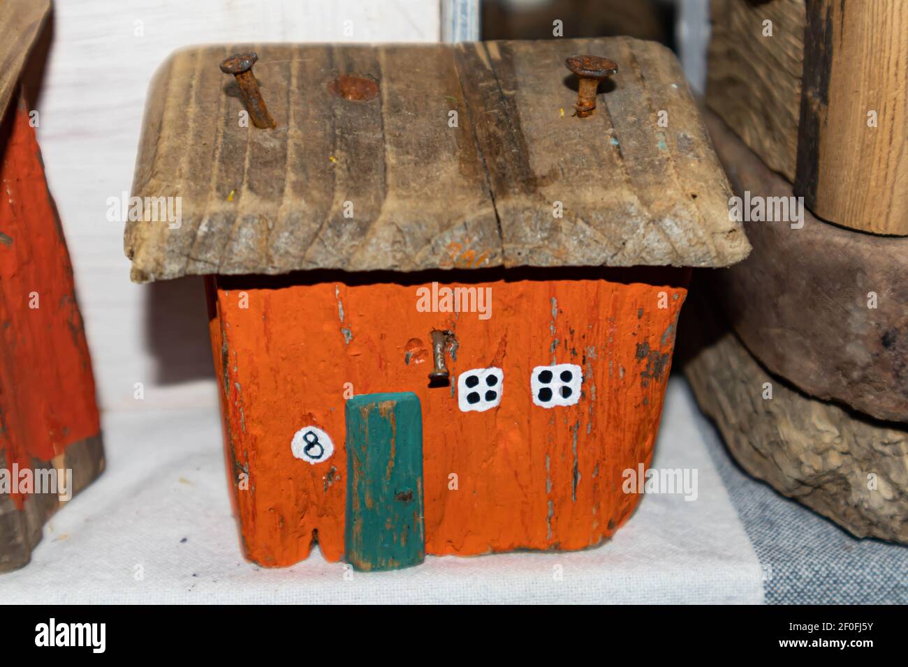 Ancienne maison en bois orange. Les clous rouillés sont entraînés dans le toit. Petites fenêtres blanches. Cabane miniature Banque D'Images