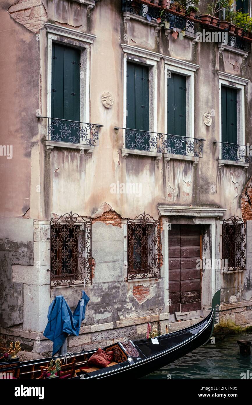 Venise, Italie. Télécabine sur un canal le long d'une façade en ruines d'un bâtiment sur un canal Banque D'Images