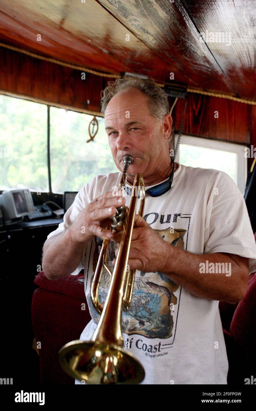 10 juin 2010. Port de plaisance de Breton Sound, Hopedale, Louisiane.  Etats-Unis - Ricky Robin, capitaine du bateau 'Li Rick.', joue sa trompette  dans la maison de roue. Robin, un pêcheur commercial