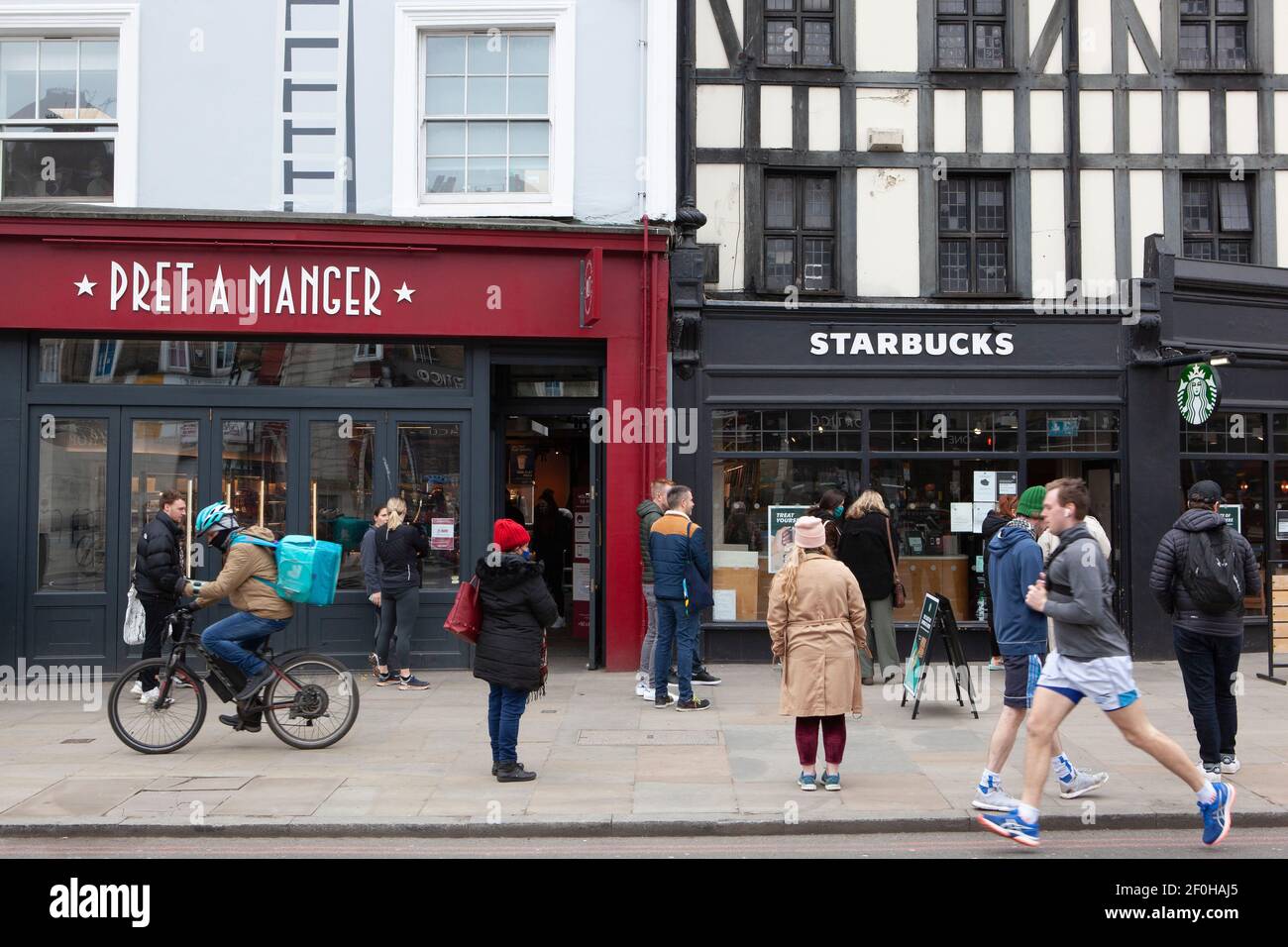 Londres, Royaume-Uni, 7 mars 2021 : les gens forment des files d'attente socialement distancées à PRET a Manger et Starbucks sur Clapham High Street. Bien que le centre de Londres soit largement déserté, les rues hautes de la banlieue sont assez occupées malgré les conseils de confinement pour ne quitter la maison que pour faire de l'exercice. Anna Watson/Alay Live News Banque D'Images