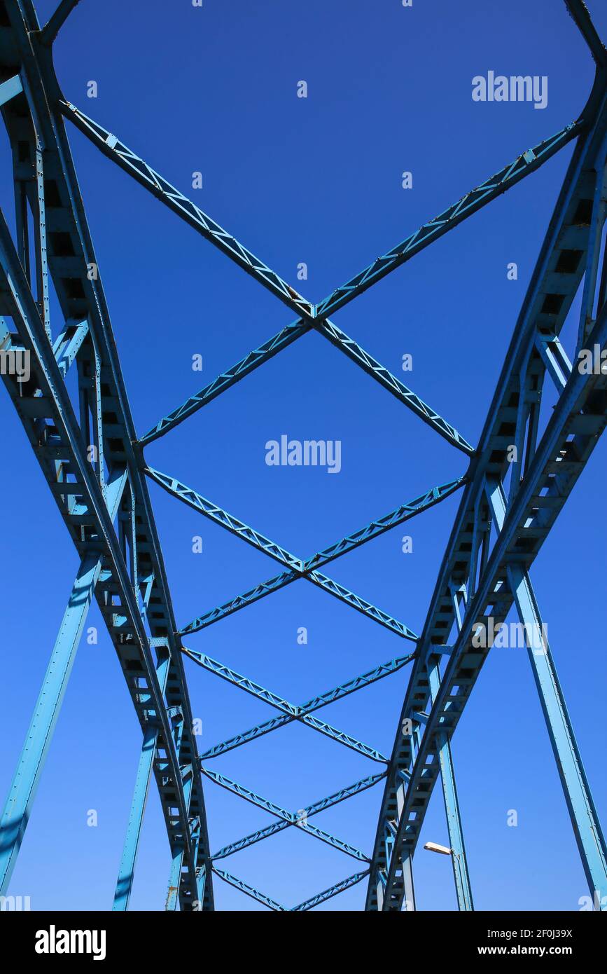 Vue à angle bas sur le pont en acier industriel symétrique isolé contre le ciel bleu avec des traverses et des poutres métalliques Banque D'Images