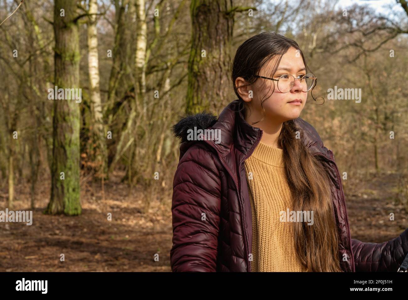 Une adolescente dans une forêt du début du printemps. Arbres et buissons en arrière-plan Banque D'Images