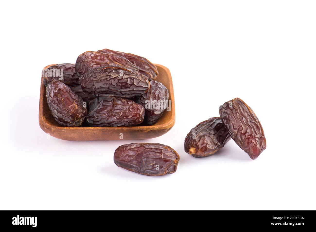 HURMA, dates. Dattes séchées fruits avec plaque en bois sur fond blanc. Fruit populaire du Ramadan. Banque D'Images