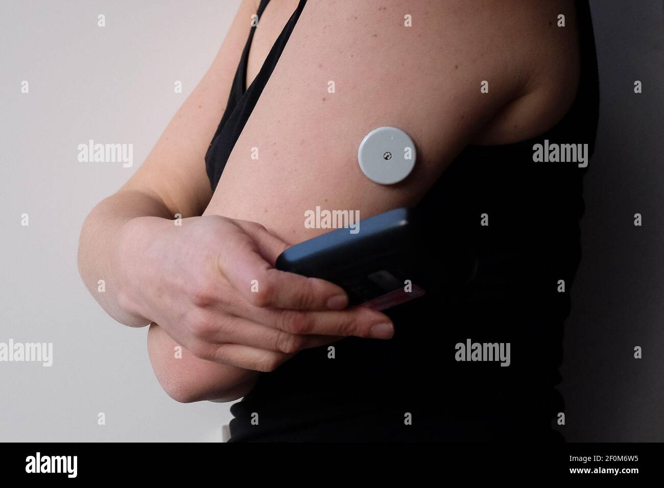 Une femme vérifie son taux de glycémie en scannant son capteur de glucose  Flash FreeStyle libre. Le dispositif habituellement porté sur le haut du  bras, aide les personnes atteintes de diabète de