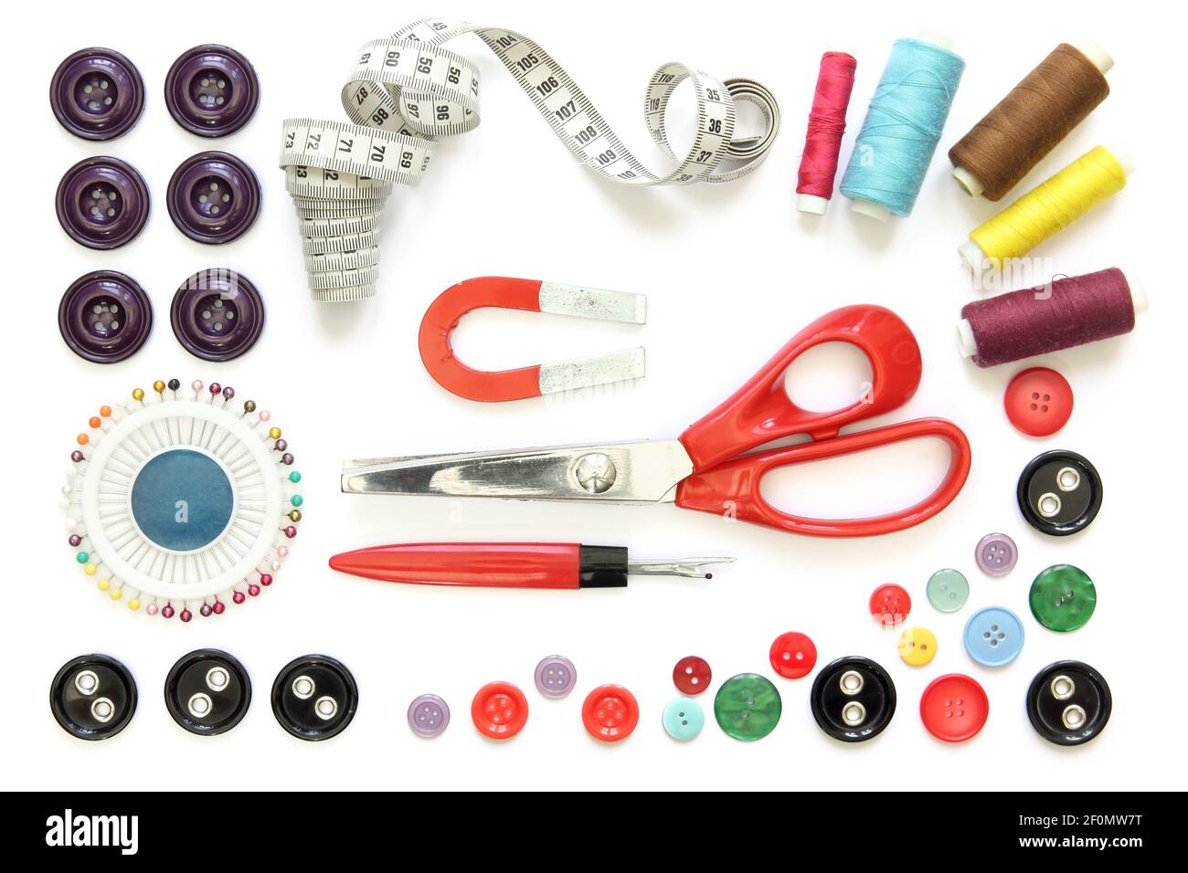 Ensemble d'accessoires de couture: Bobines de fil, aiguille, une paire de ciseaux à bouton et un mètre à ruban Banque D'Images