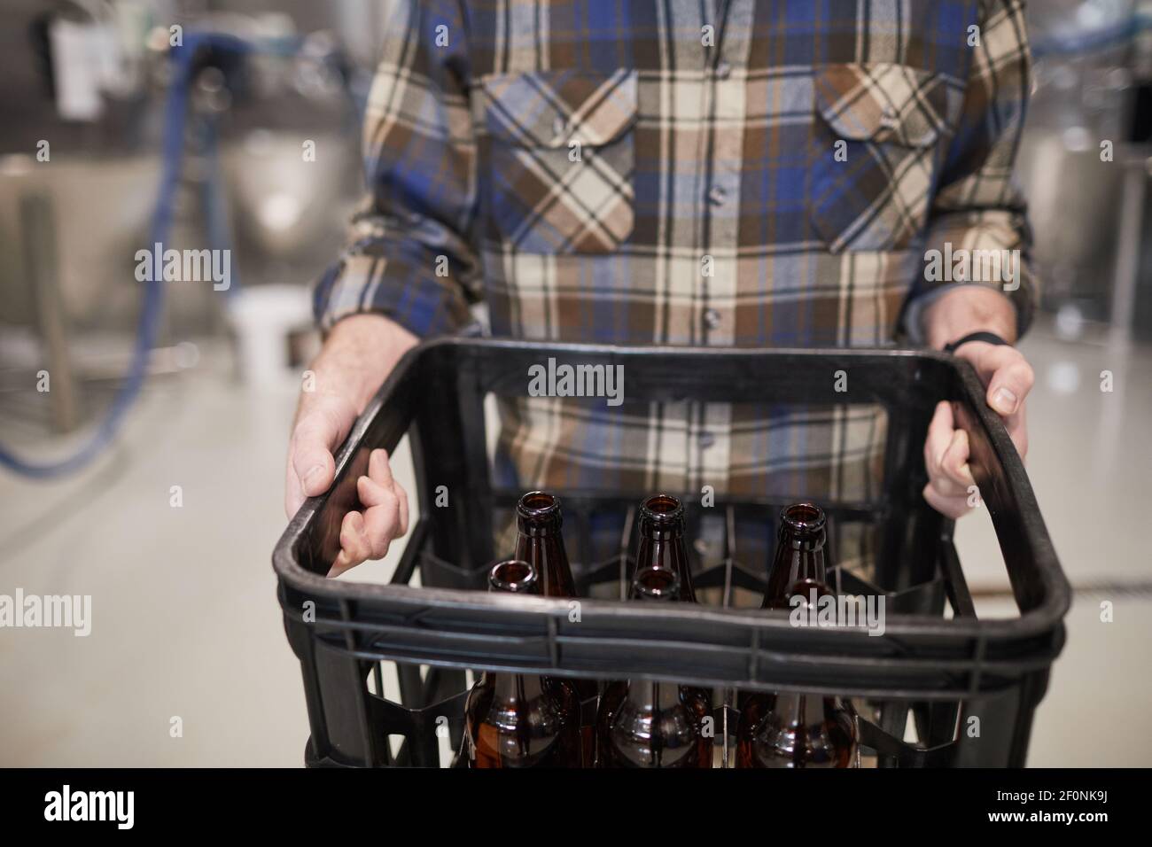 Plan de culture d'un travailleur méconnaissable contenant une boîte de bouteilles de bière à l'usine de brassage, espace réservé aux copies Banque D'Images