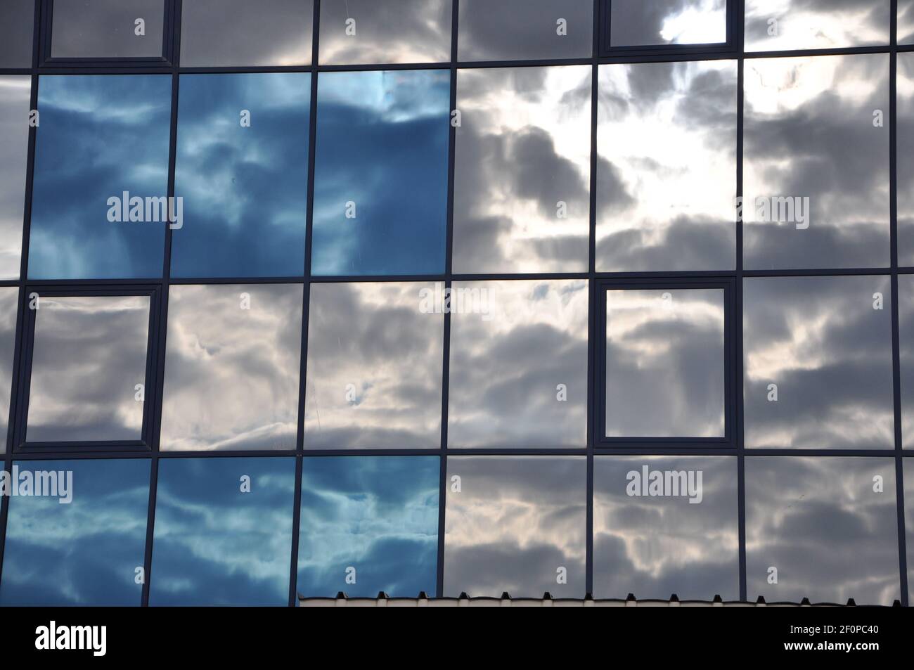 Gratte-ciels modernes en verre du centre d'affaires avec nuages réfléchissants Banque D'Images