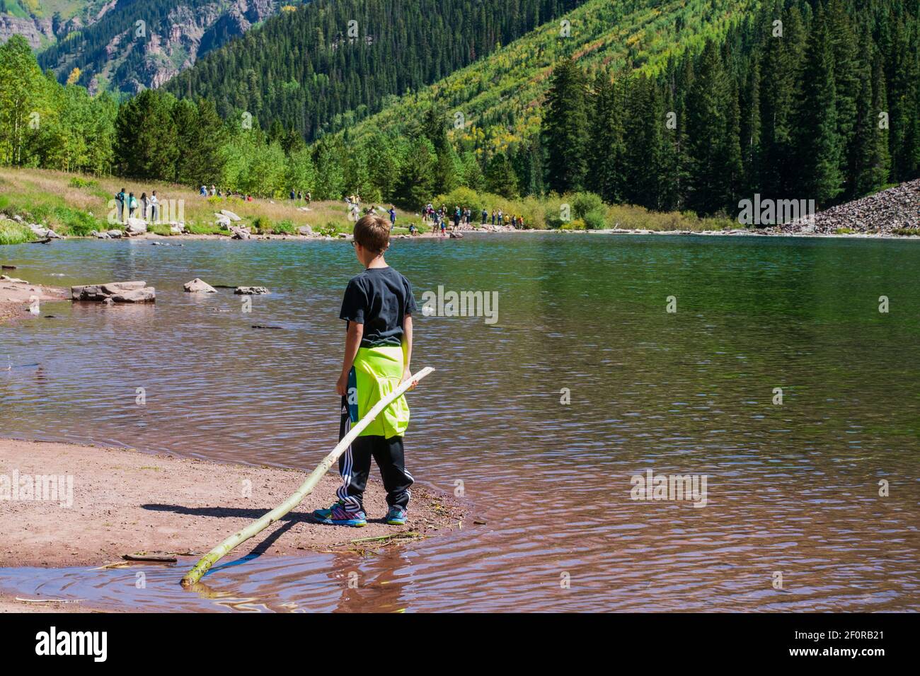 Maroon Bells, Aspen, Colorado, États-Unis -- 13 septembre 2014. Un jeune garçon se tient au bord de Maroon Creek par Aspen Colorado. Banque D'Images