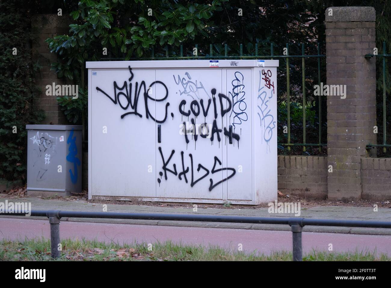 Amersfoort, pays-Bas-Januari 31,2021:Graffiti texte 'Covid Hoax' spray peint sur une petite maison électrique sur le côté de la route. Banque D'Images