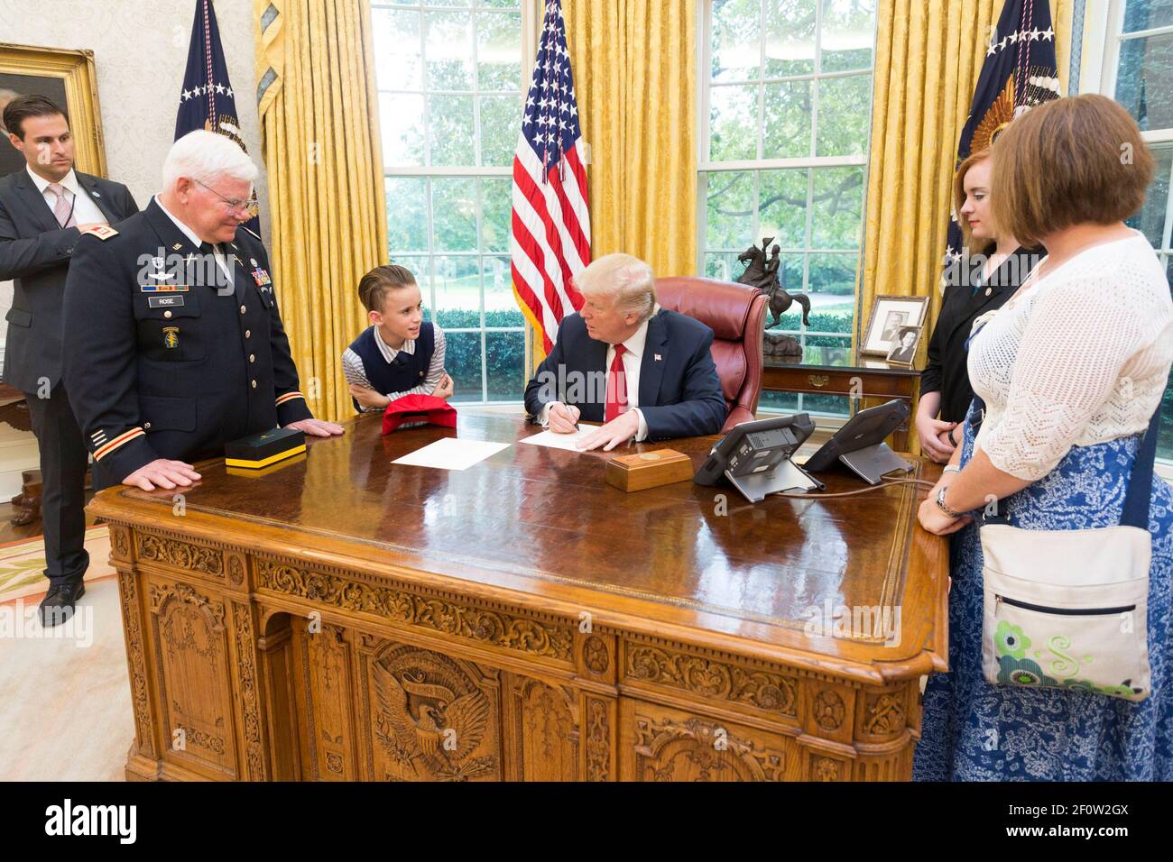Le président Donald Trump écrit une note d'excuse de l'école pour le récipiendaire de la Médaille d'honneur retraité capitaine de l'armée américaine Gary M. Rose petit-fils Christian est parti lors d'une visite de famille dans la salle ovale de la Maison Blanche à Washington D.C. | octobre 23 2017 Banque D'Images