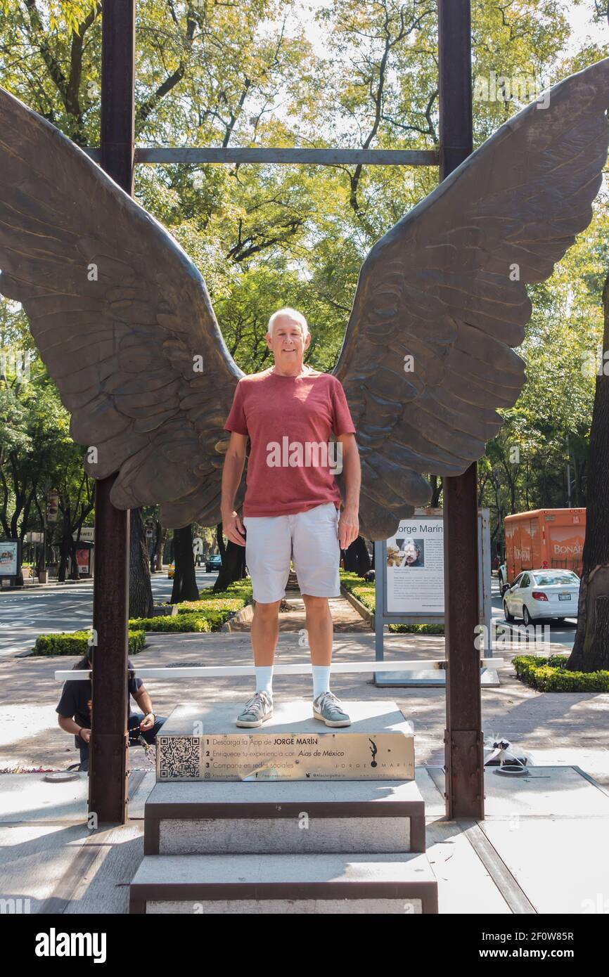 L'homme pose devant la sculpture des ailes du Mexique par Jorge Marin sur l'avenue Paseo de la Reforma, Mexico, Mexique Banque D'Images