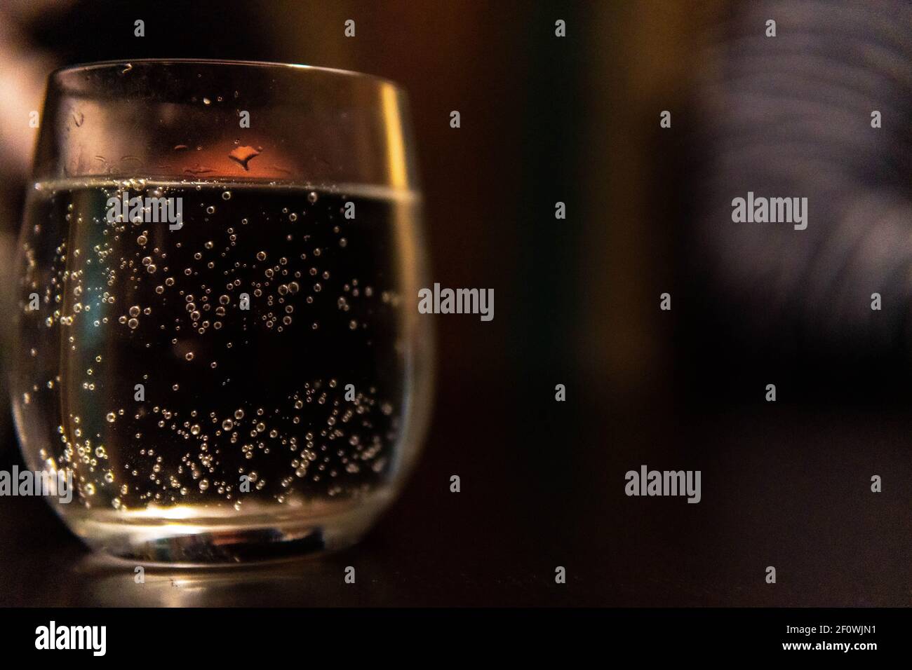 De l'eau pétillante dans un verre la nuit Banque D'Images