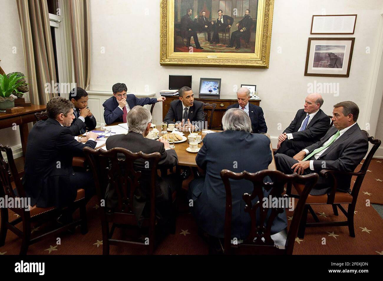 Le président et le vice-président convoquent une réunion en fin de soirée pour discuter du budget avec John Boehner, à droite, et Harry Reid, deuxième de gauche en premier plan, dans la salle à manger privée du Bureau ovale. Sur la photo du vice-président, dans le sens des aiguilles d'une montre, on trouve Bill Daley; le président Boehner; Barry Jackson, le sénateur Reid; David Krone, Rob Nabors et Jack Lew, vers. 6 avril 2011 Banque D'Images