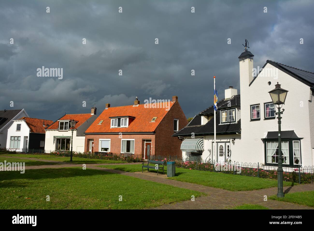 Rue et maisons dans la ville de Renesse, Zeeland, pays-Bas, avec ciel  sombre et soleil Photo Stock - Alamy