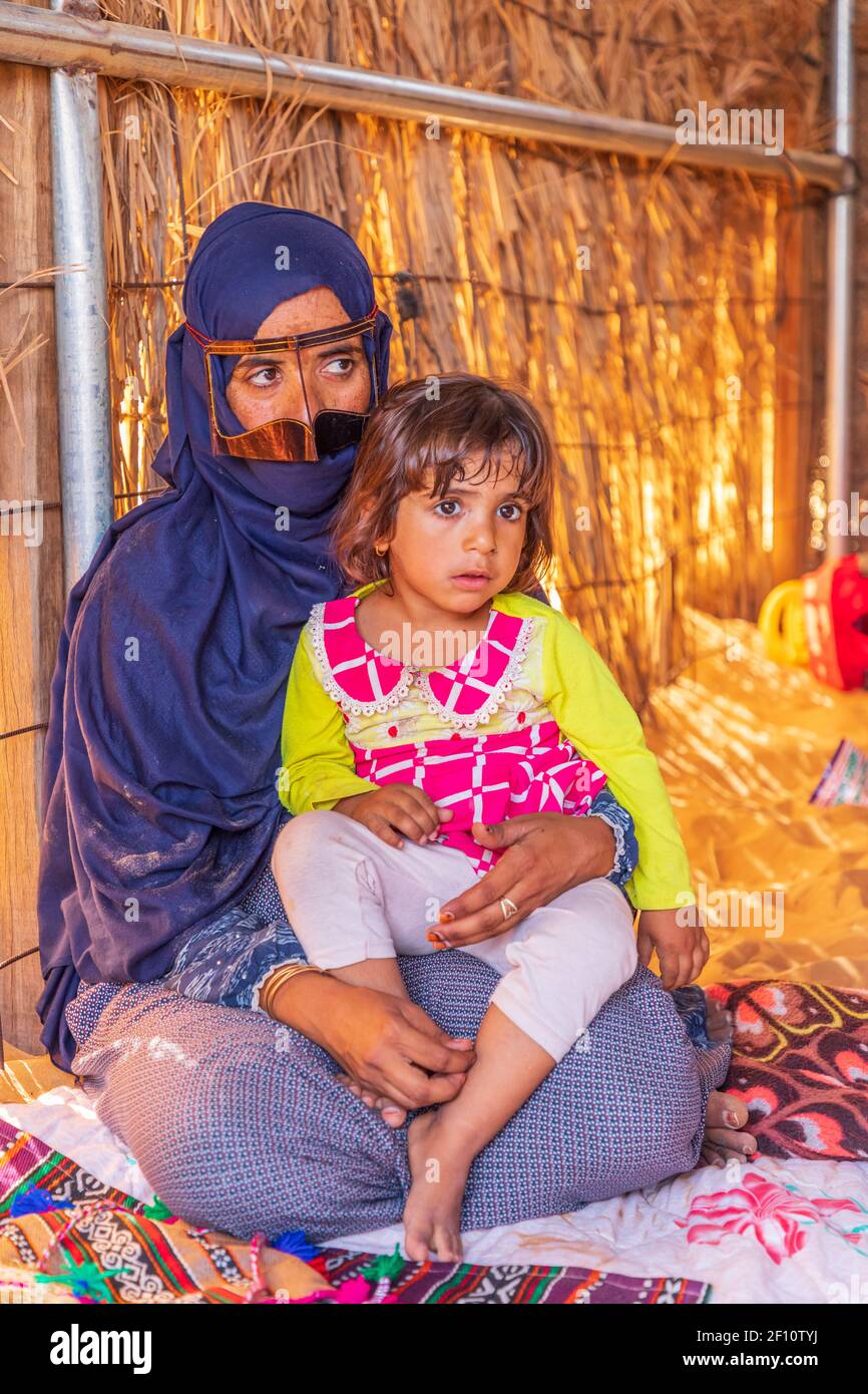 Moyen-Orient, Péninsule arabique, Oman, Ash Sharqiyah Nord, Bidiya. 26 octobre 2019. Femme omanaise en hijab bleu et battoulah métallique avec une jeune fille. Banque D'Images