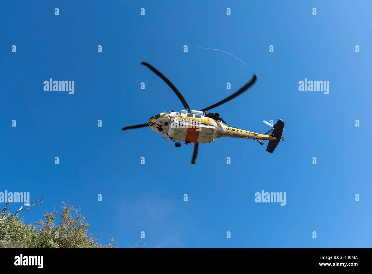 Montagnes San Gabriel, Californie, États-Unis - 4 mars 2021 : hélicoptère du service des incendies du comté de Los Angeles volant bas dans la forêt nationale d'Angeles. Banque D'Images