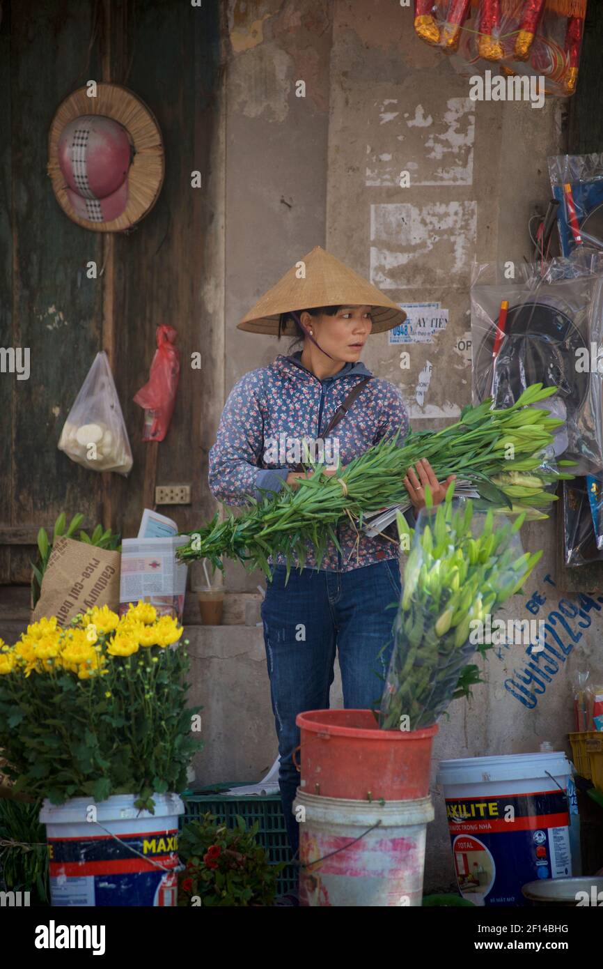 Vie de rue vietnamienne. Vendeur de fleurs de bord de route, Hanoï, Vietnam Banque D'Images