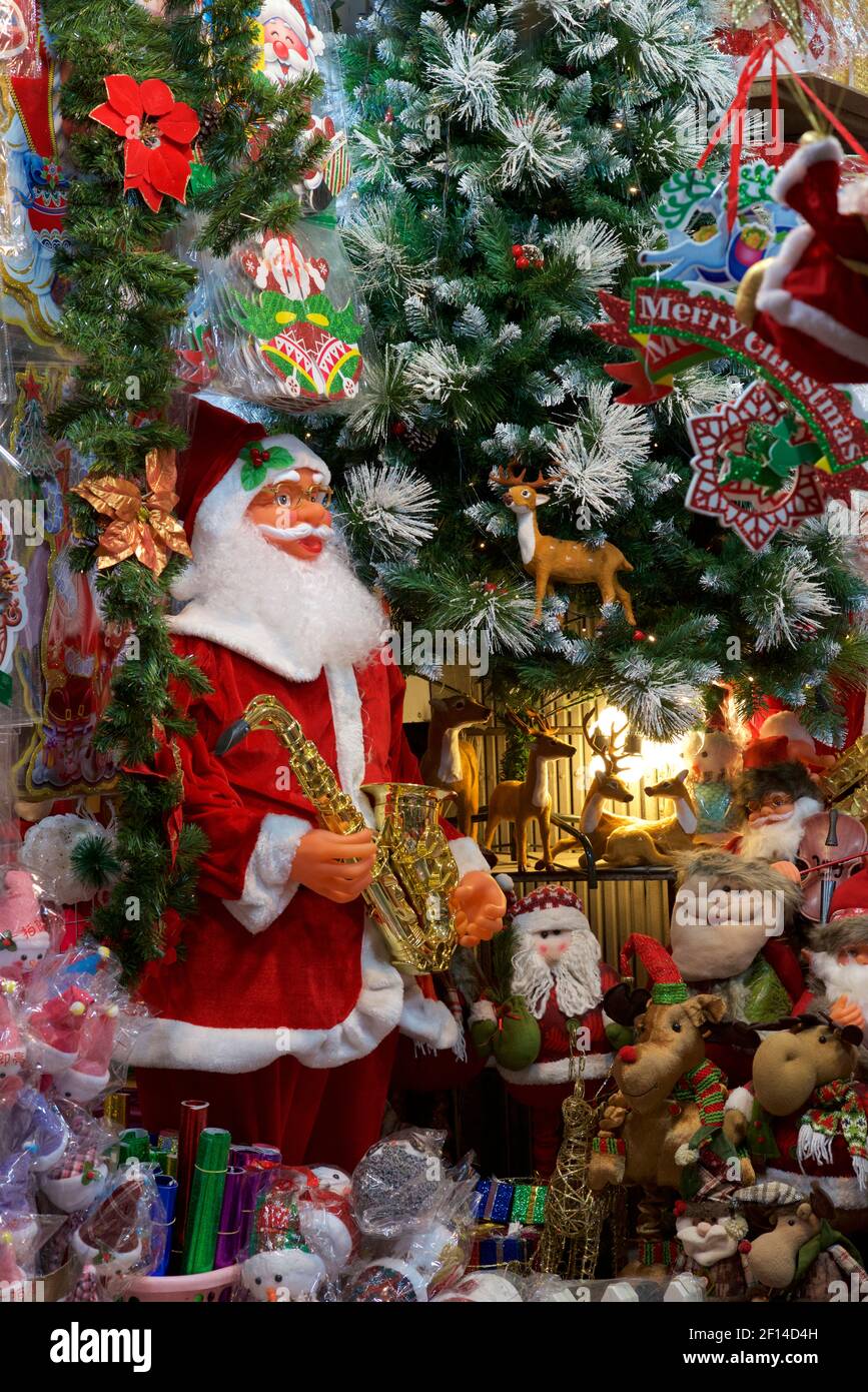 Détail des marchandises à vendre dans un magasin, Hanoi, Vietnam. Décorations de Noël dont le Père Noël et l'arbre de Noël Banque D'Images