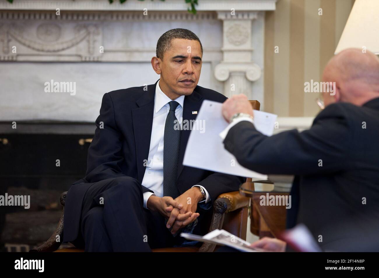 Le président Barack Obama étudie un document tenu par le directeur du renseignement national James Clapper lors de la réunion d'information présidentielle dans le Bureau ovale le 3 2011 février. Banque D'Images