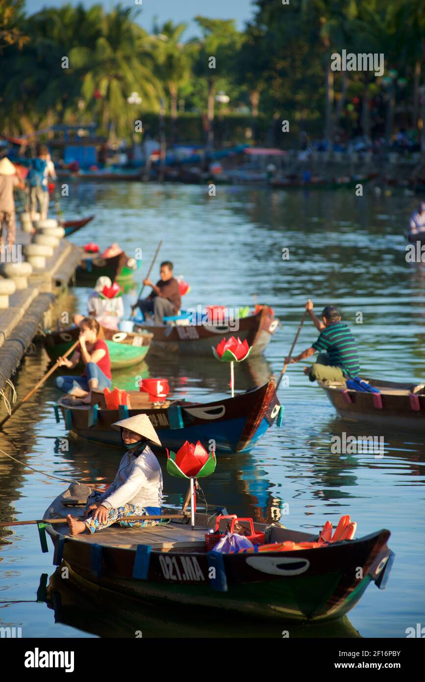 Une femme vietnamienne attend pour emmener les touristes sur un court voyage en bateau le long des canaux et de la rivière Thu bon, Hoi an, Vietnam Banque D'Images