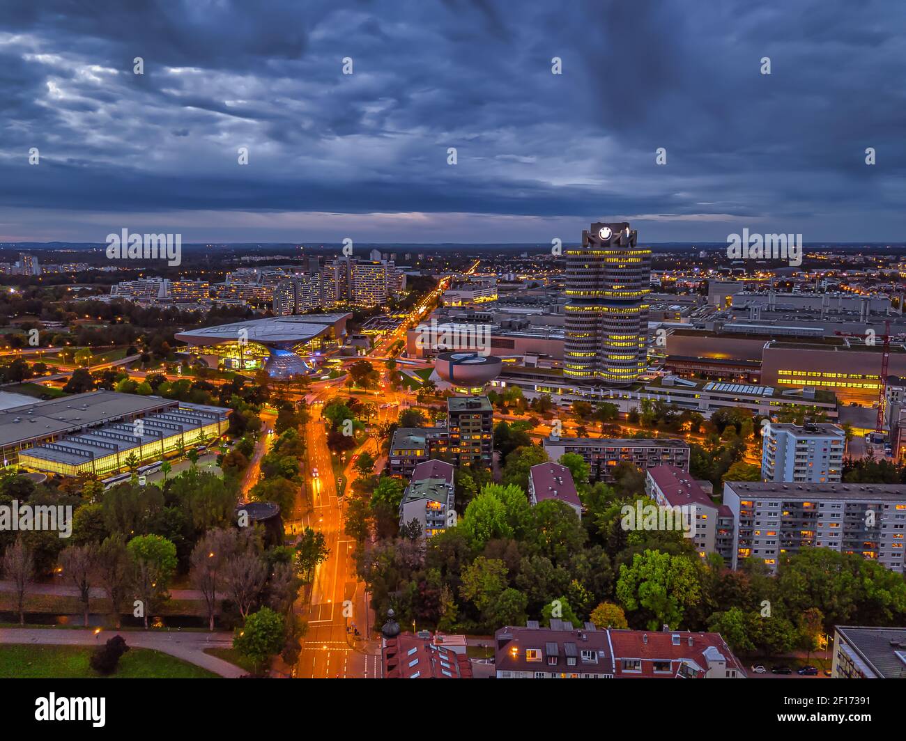 Vue magnifique au crépuscule sur Munich illuminée avec quartier des affaires et voitures sur une route d'un point de vue élevé. Banque D'Images