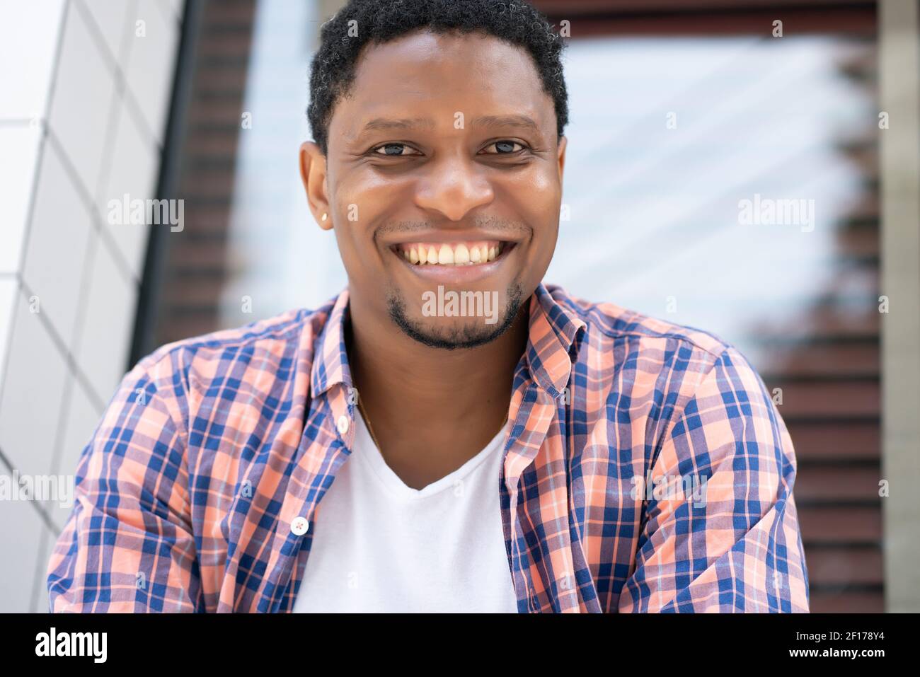 Homme afro-américain assis à la fenêtre d'un magasin. Banque D'Images