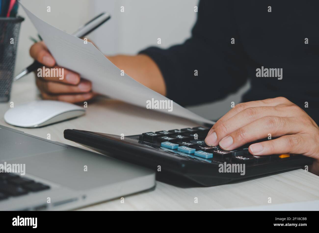 Homme d'affaires utilisant la calculatrice à un bureau. Finance d'entreprise, impôts et concepts d'investissement. Banque D'Images
