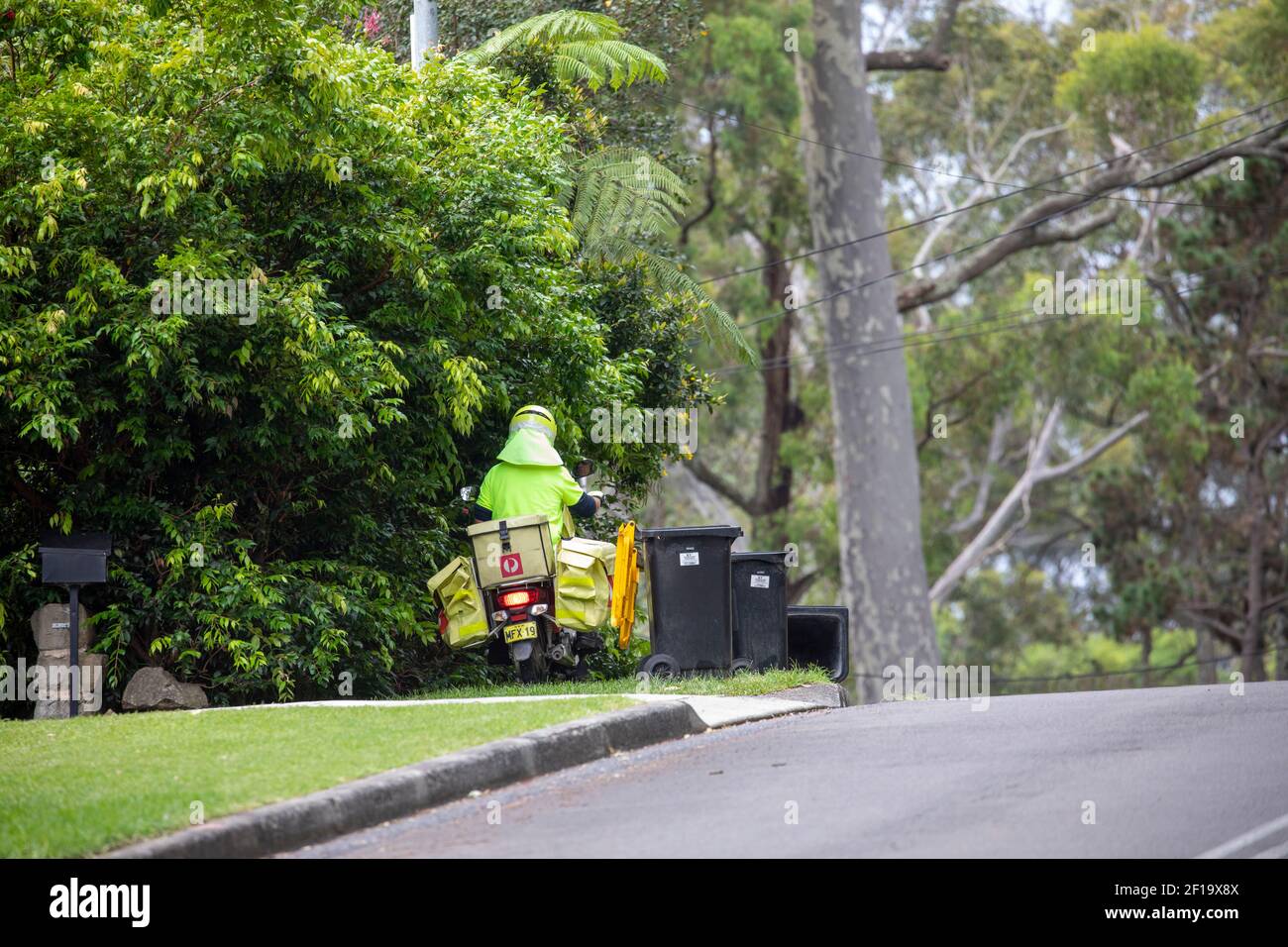 Un postier de poste en Australie livre du courrier à domicile sur sa moto, Sydney, NSW, Australie Banque D'Images