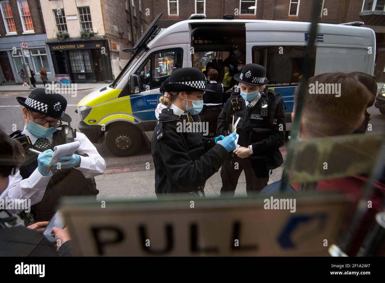 Des officiers de police et des gendarmes spéciaux arrêtent et interrogez les suspects devant un point de vente de nourriture à London Bridge lors d'une opération de toutes les femmes par la police métropolitaine, la première du genre pour la force, pour marquer la Journée internationale de la femme. Date de la photo: Samedi 6 mars 2021. Banque D'Images