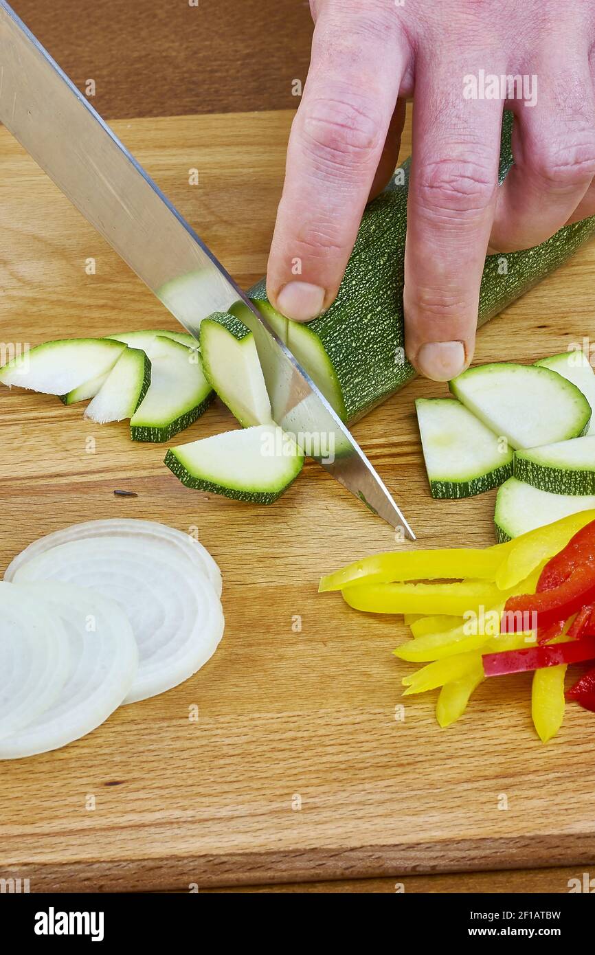 Le chef coupe les recettes complètes de cuisine de la série d'oignons de concombre Banque D'Images