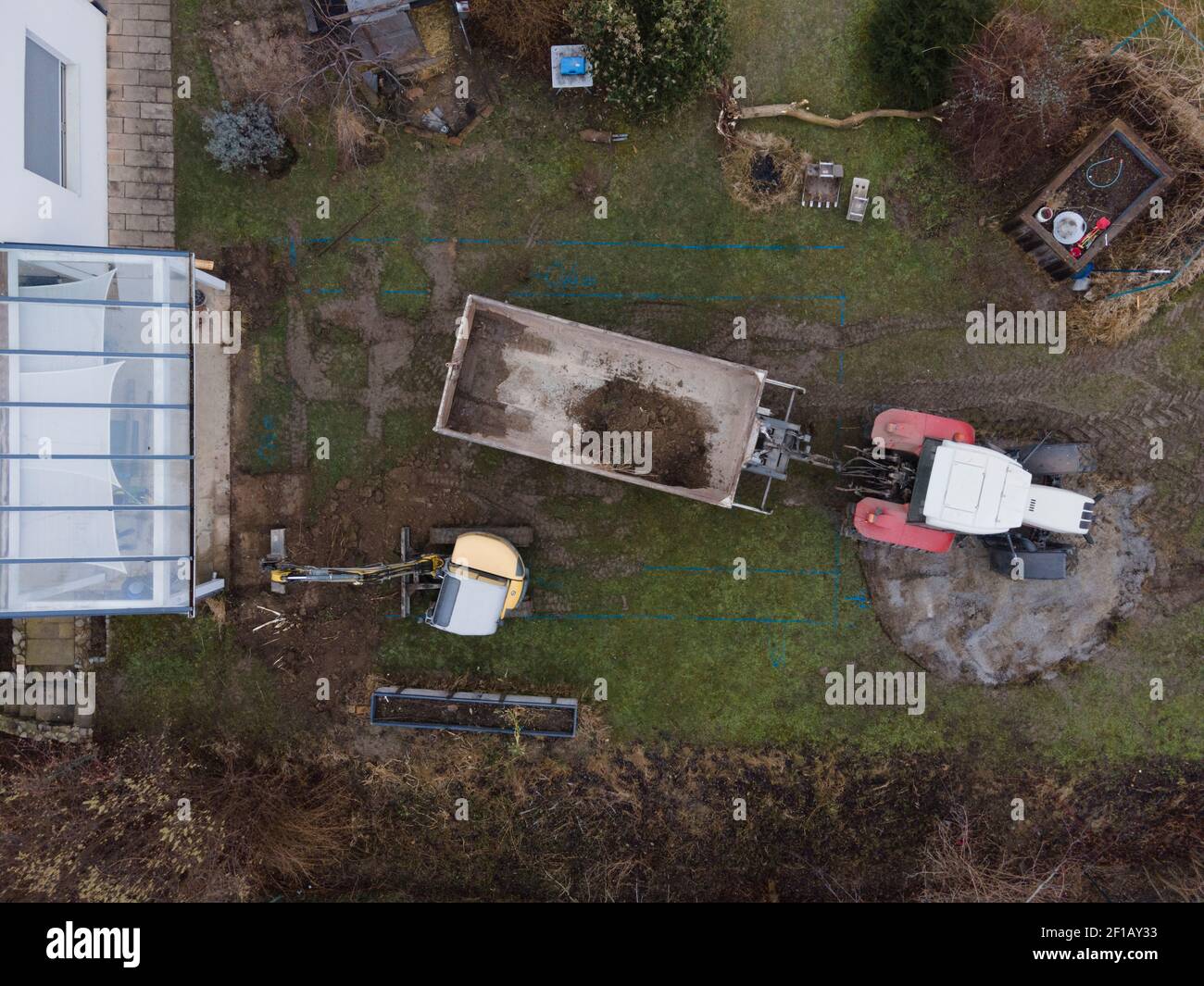 un tir de drone aérien de petite pelle jaune se tient dans un grand jardin  et creuse un trou pour une piscine en autriche Photo Stock - Alamy
