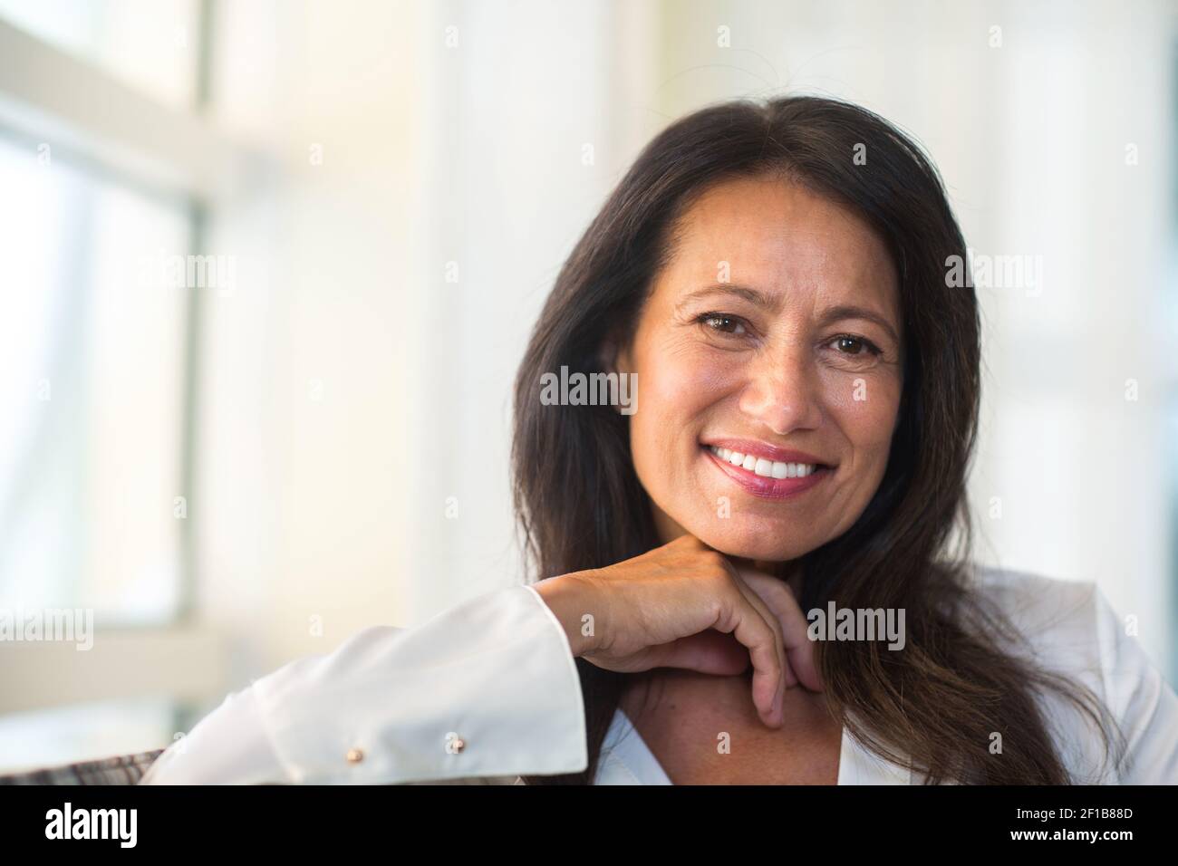 Belle femme mûre assise sur le canapé Banque D'Images