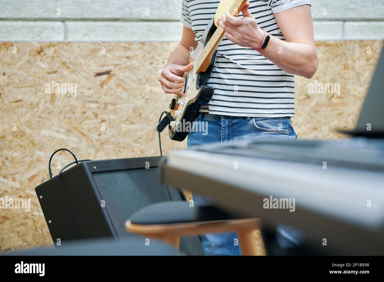 Beau homme jouant de la guitare en studio Banque D'Images