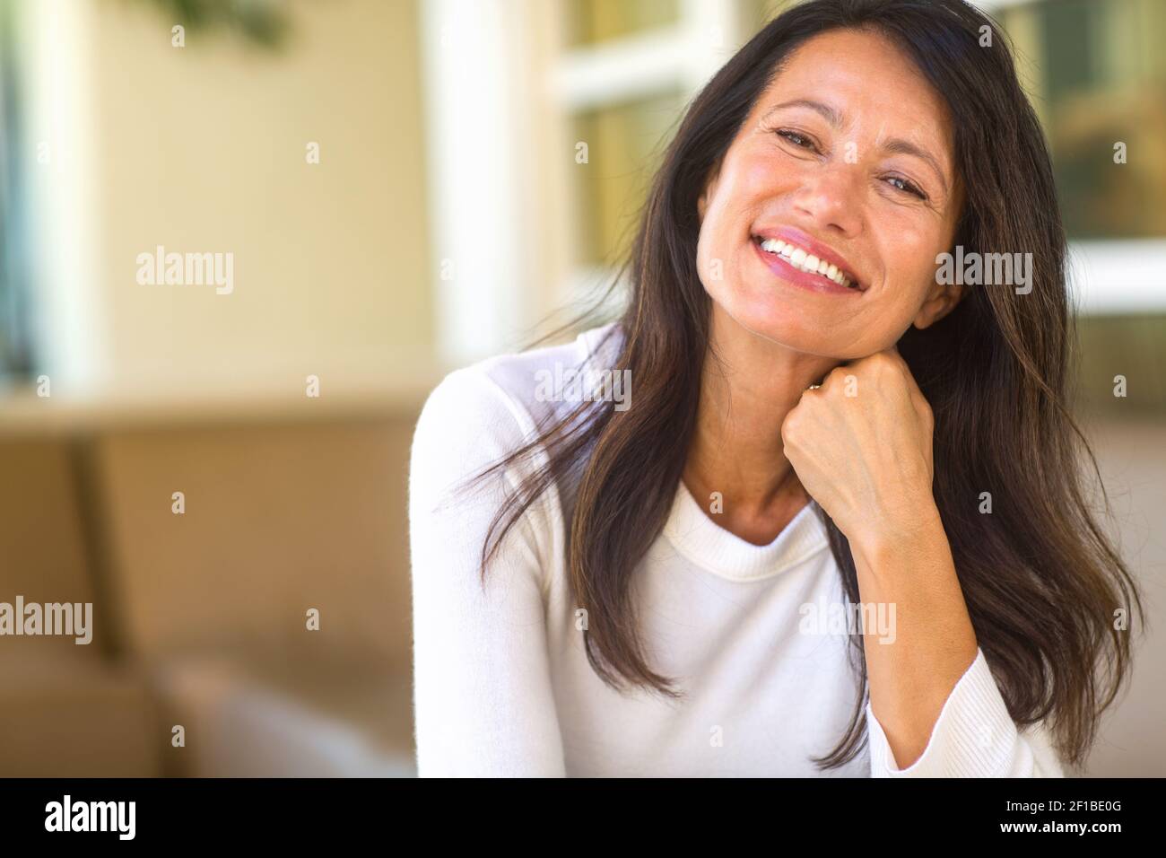 Portrait d'une belle femme mûre assise sur le canapé Banque D'Images