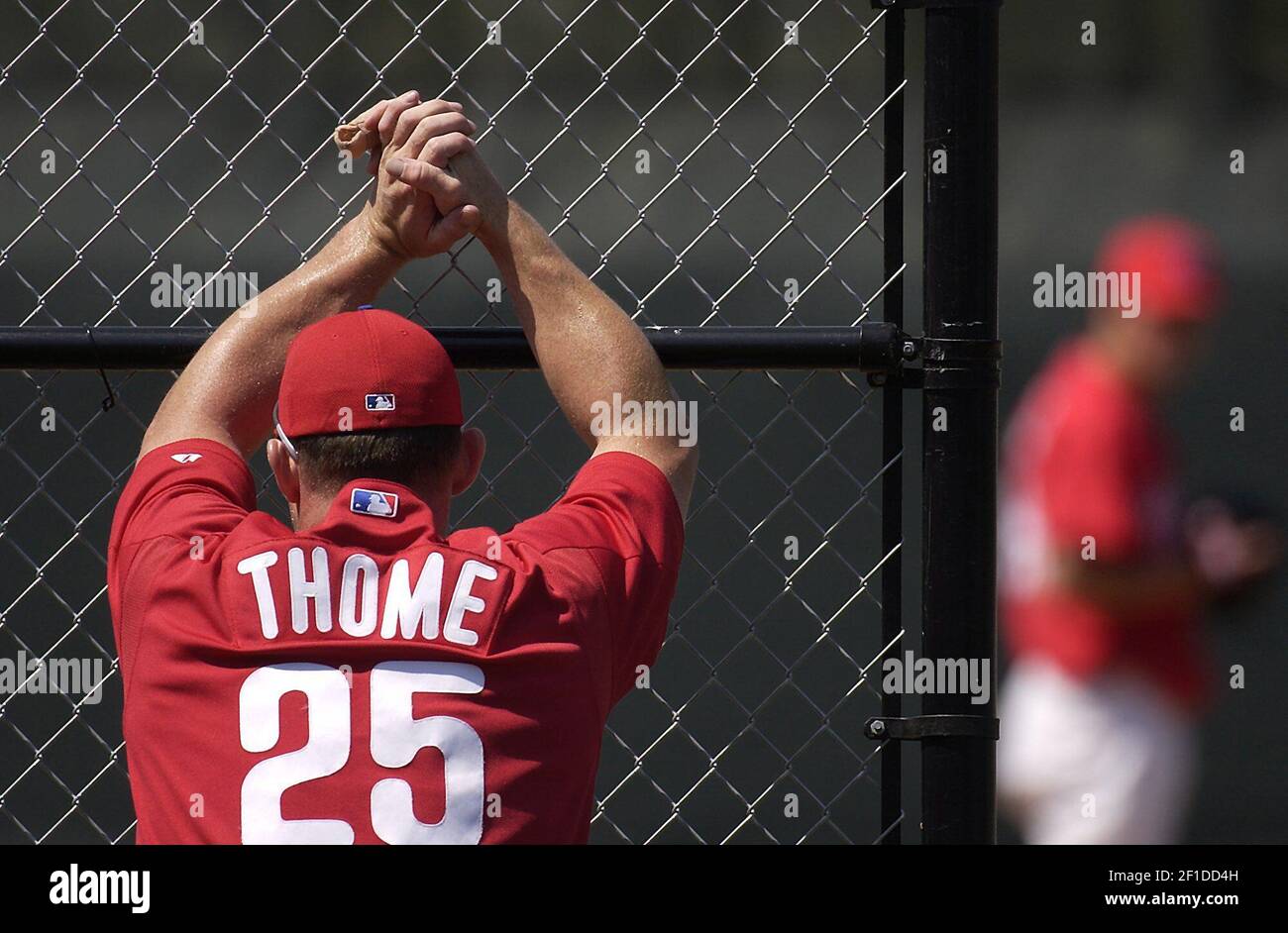 KRT STAND SEUL PHOTO DE SPORT: PHILLIES-SPRINGTRAINING KRT PHOTOGRAPHIE PAR ERIC MENCHER/PHILADELPHIA INQUIRER (MARS 22) CLEARWATER, FL -- Le slugger Jim Thome de Philadelphie Phillies (avec le doigt du milieu bandé) observe à travers une clôture avant que les pirates de Pittsburgh jouent les Phillies de Philadelphie au Bright House Networks Field à Clearwater, Floride, le 18 mars 2004. (Photo du mdp) 2004 Banque D'Images