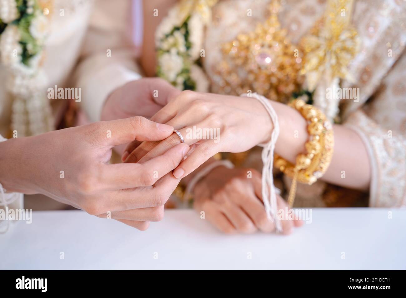Portant un anneau de mariage, le marié porte un anneau de mariage sur le  doigt de la mariée. Mariages en Thaïlande Photo Stock - Alamy