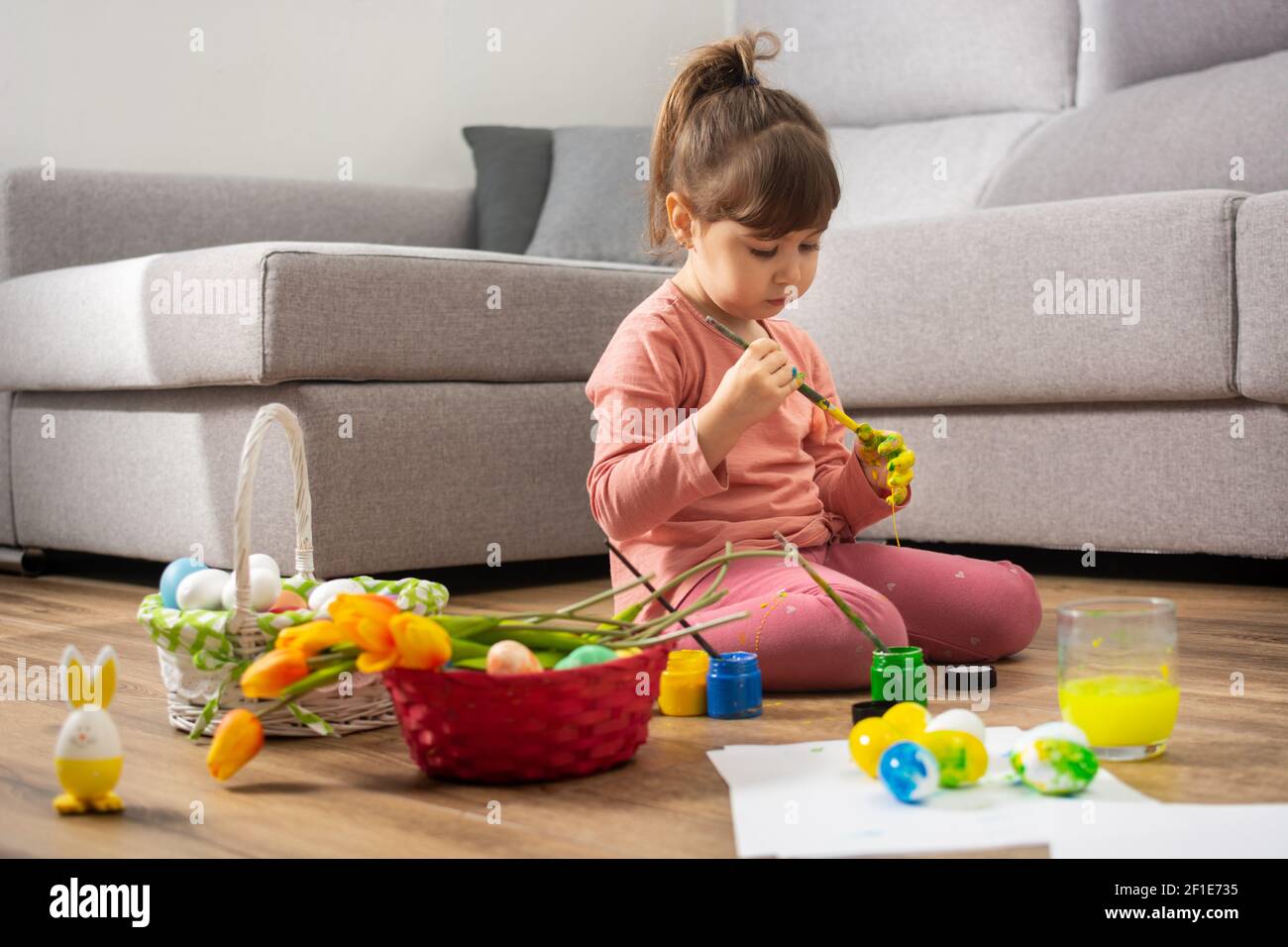 Bébé fille peignant des oeufs de Pâques à la maison Banque D'Images