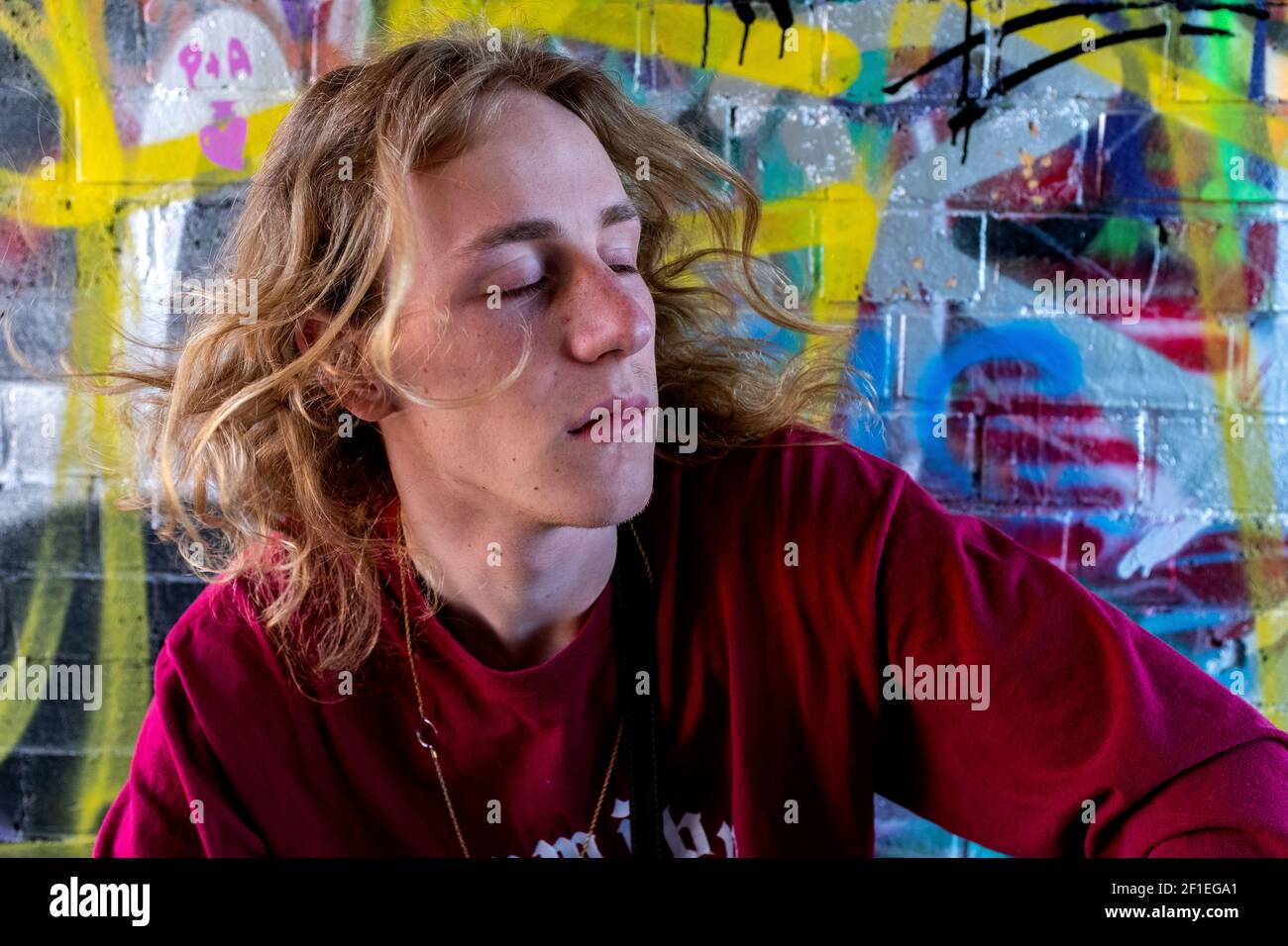 Berlin, Allemagne. Portrait urbain d'un jeune mâle adulte, étudiant en musique à l'intérieur d'un tunnel piétonnier infestés graffity. Banque D'Images