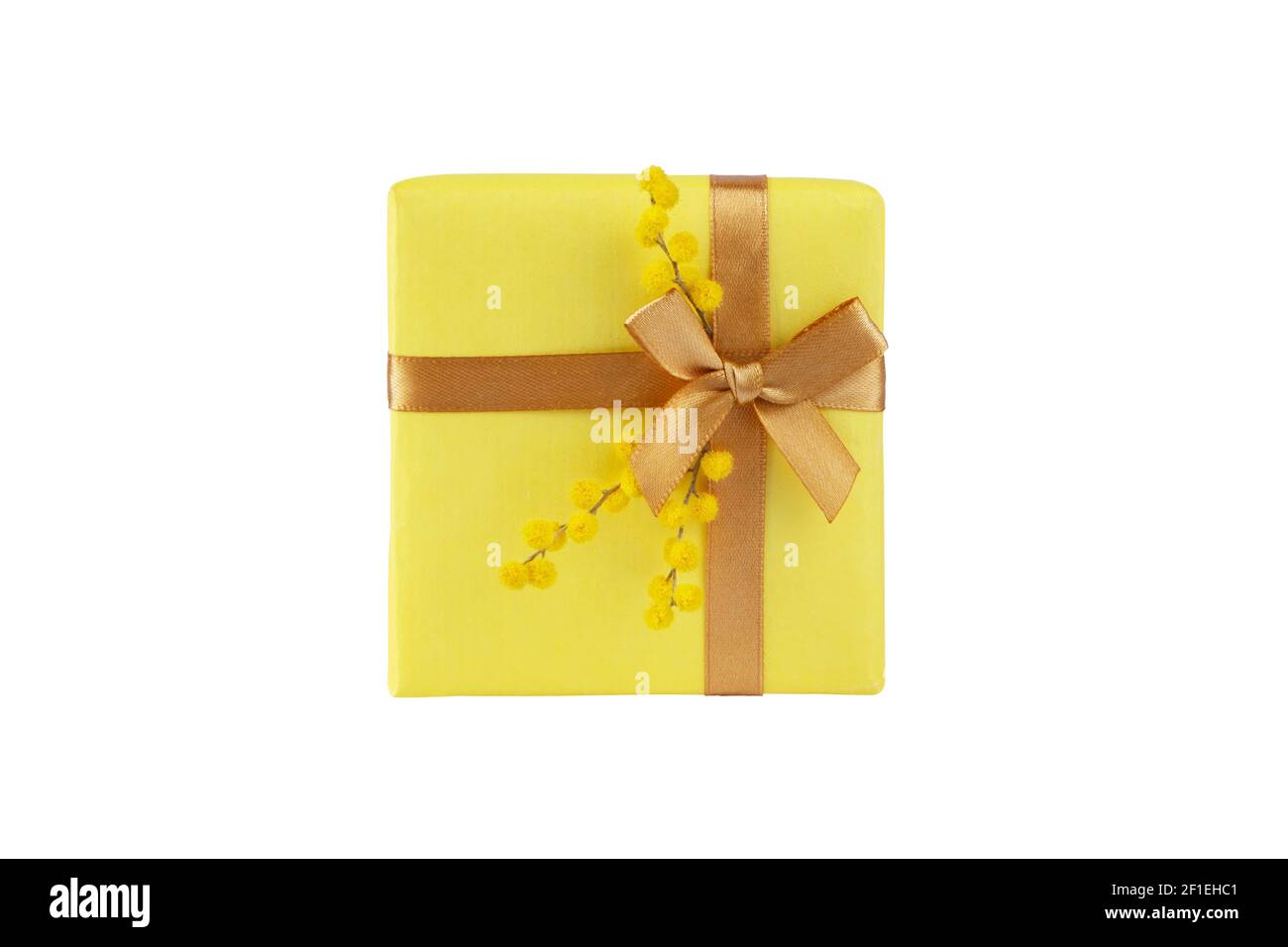 Boîte cadeau jaune avec noeud en ruban doré et fleurs moelleuses mimosa vue sur le dessus isolée sur blanc. Vacances de printemps. Banque D'Images