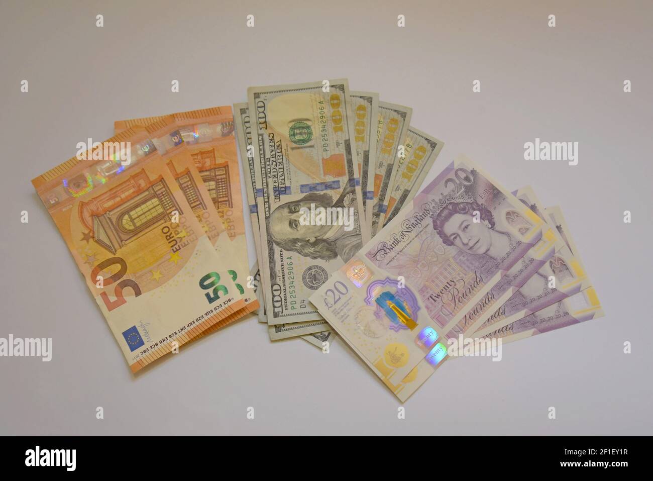 Une sélection de billets en livres sterling, en euros et en dollars américains sur fond blanc Banque D'Images