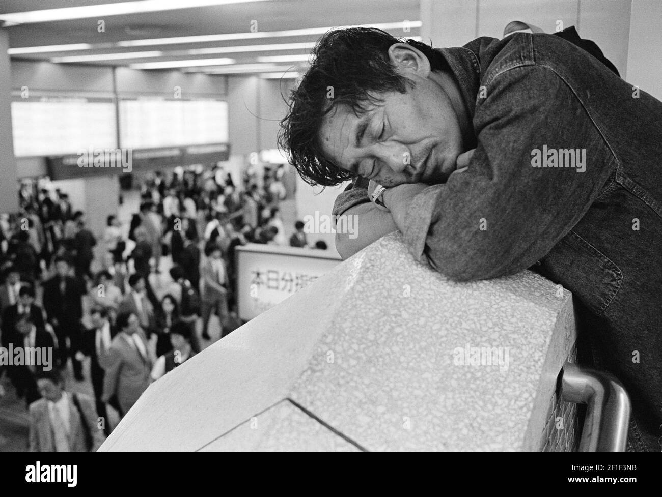 Les personnes qui marchent à pied après un homme sans abri dormant dans le métro, Tokyo, Japon Banque D'Images