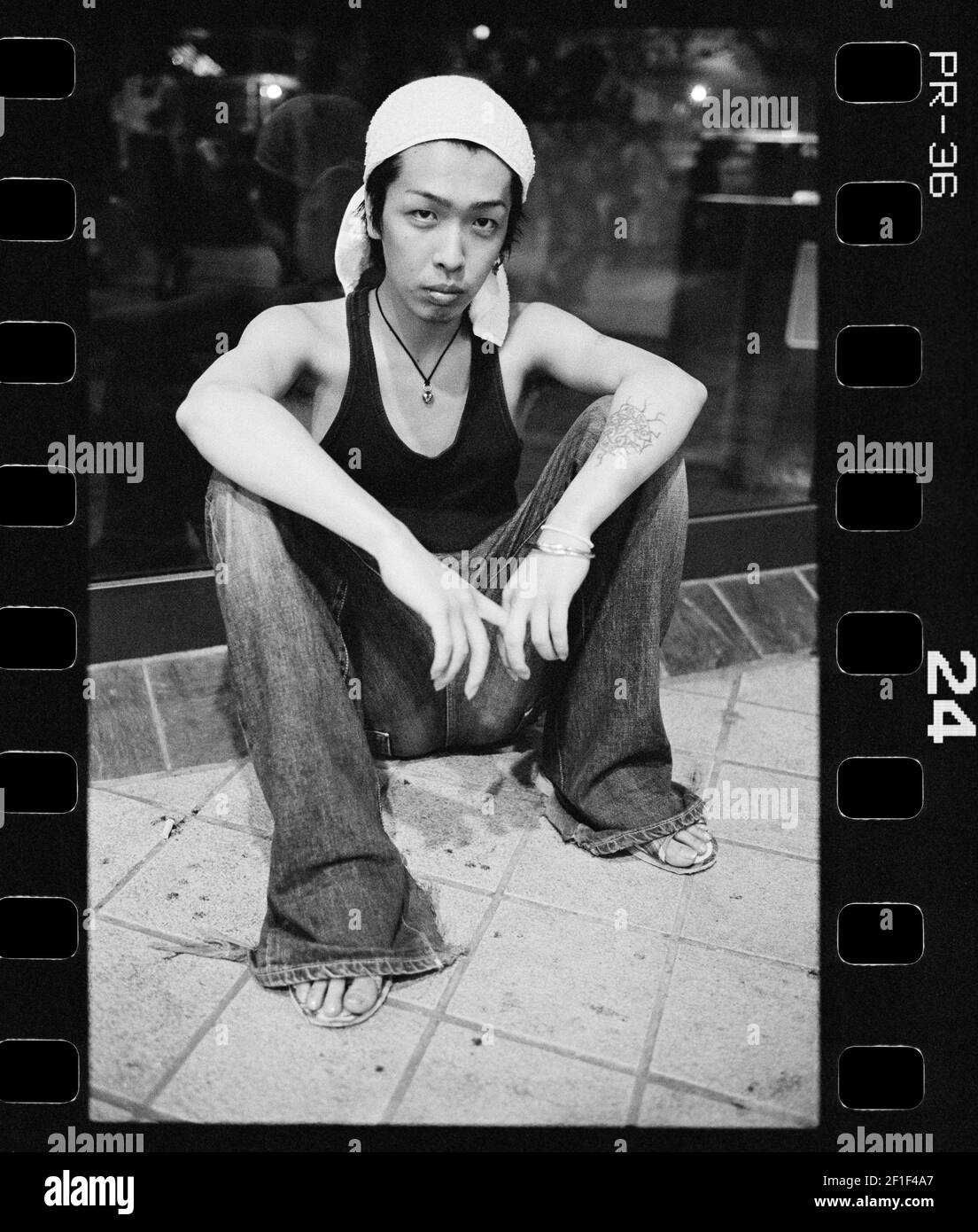 Jeune homme avec un pantalon de jeans évasé assis dans la rue , Osaka en 1998 , Japon Banque D'Images