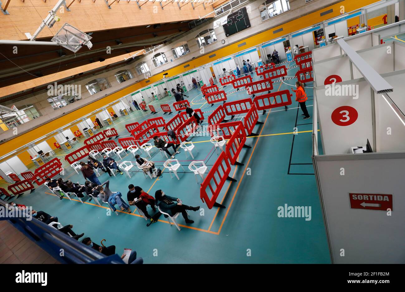 Palma, Espagne. 08 mars 2021. Les personnes avec des masques attendent une vaccination Corona dans le centre sportif 'Germans Escalas' dans le cadre d'une vaccination de masse du personnel essentiel. TUI compte sur un redémarrage de l'importante entreprise de Majorque dans les prochaines vacances de Pâques. Credit: Clara Margais/dpa/Alay Live News Banque D'Images